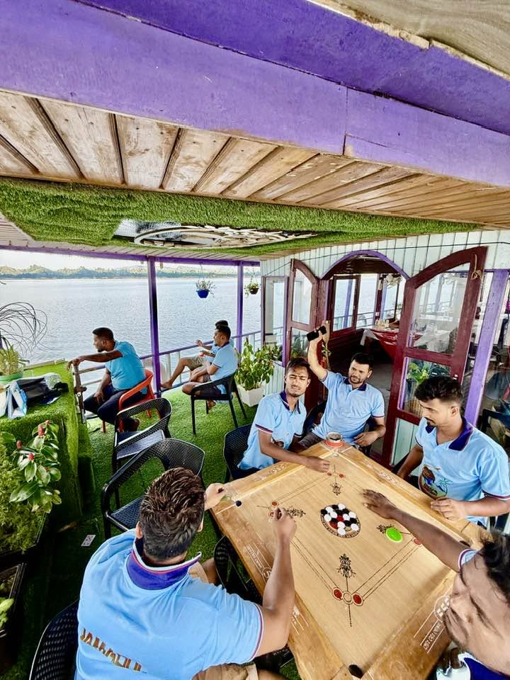 Friends Enjoying a Game of Carrom on the Deck