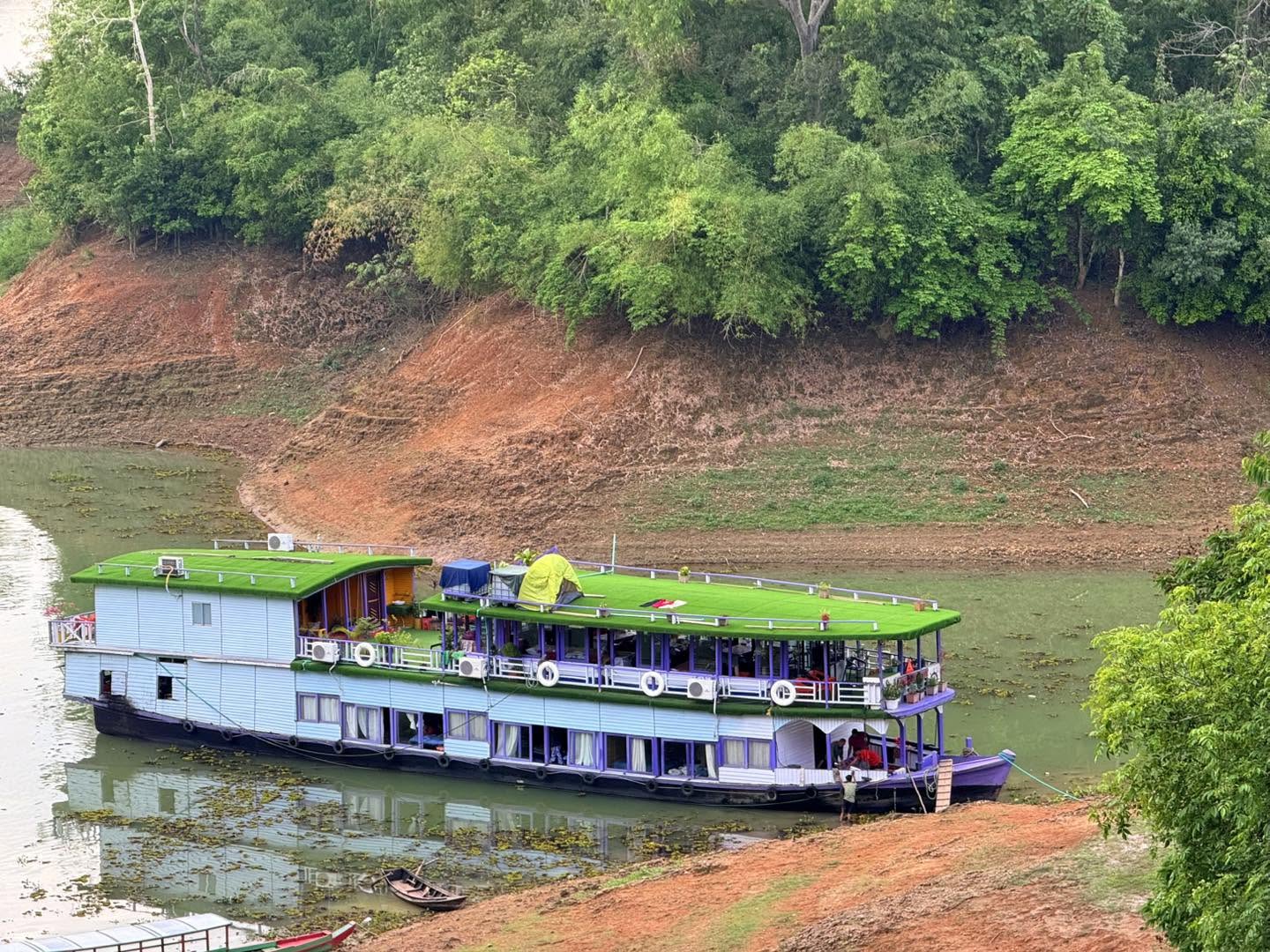 The Royal Boat Docked at a Lush Green Shore